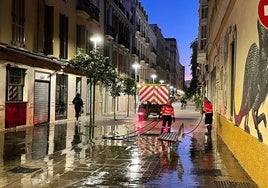 Operarios de Limasam baldeando una calle en la zona del Soho.