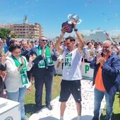 Javi Amaya alza el trofeo de campeón del grupo 9 de Tercera RFEF, que implica el ascenso, delante de las autoridades.