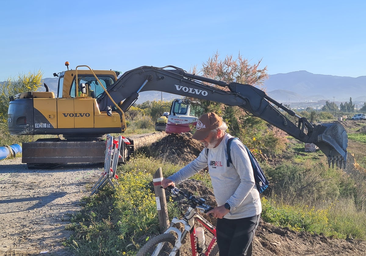 Un ciclista pasa junto a las máquinas en la zona donde se ejecutan las obras, en Puente del Rey, en una imagen de abril.