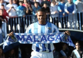 El jugador brasileño Julio Baptista posa en el césped de La Rosaleda con una bandera y una bufanda, ante 3.500 espectadores, en su presentación oficial como nuevo fichaje del Málaga en 2011.