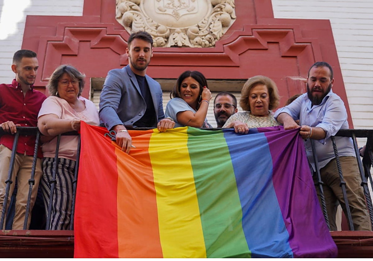 El responsable de políticas Lgtbi del PSOE-A, Manolo Rosado, a la derecha colocando la bandera de este colectivo en la sede socialista de Sevilla.