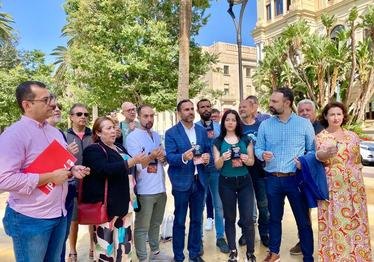 Los socialistas con los 'flyers' que han hecho bajo el título 'Salvemos a la OFM' y los lazos negros y blancos, que están repartiendo, en el paseo del Parque, frente al Ayuntamiento.