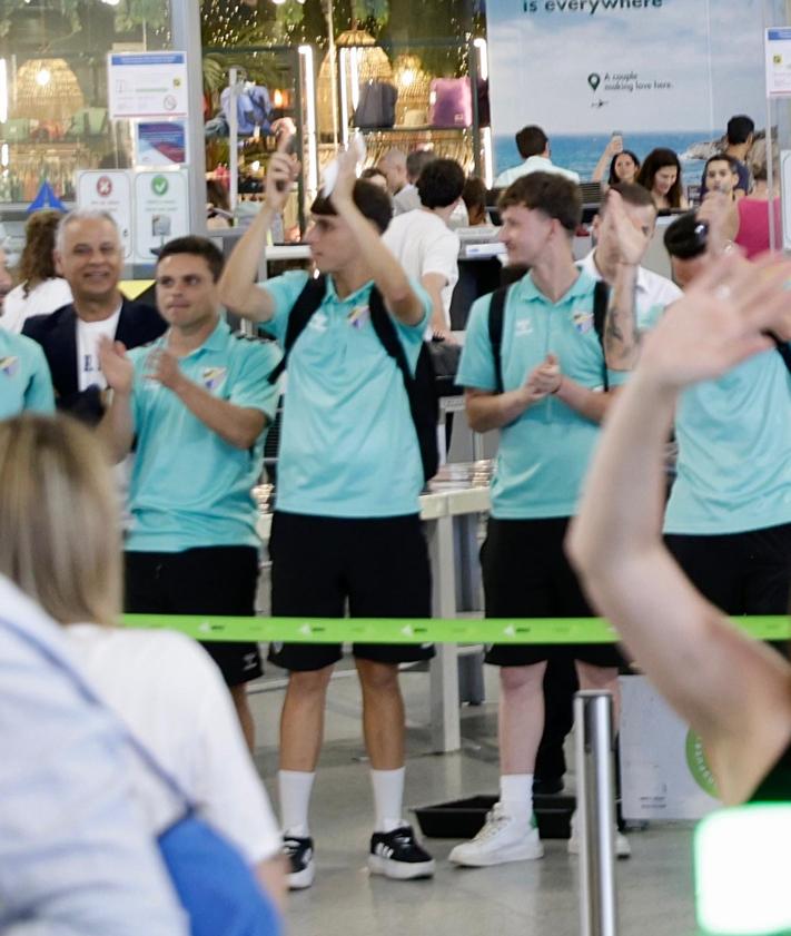 Imagen secundaria 2 - Cientos de aficionados emocionan al Málaga en el aeropuerto antes de viajar a Vigo