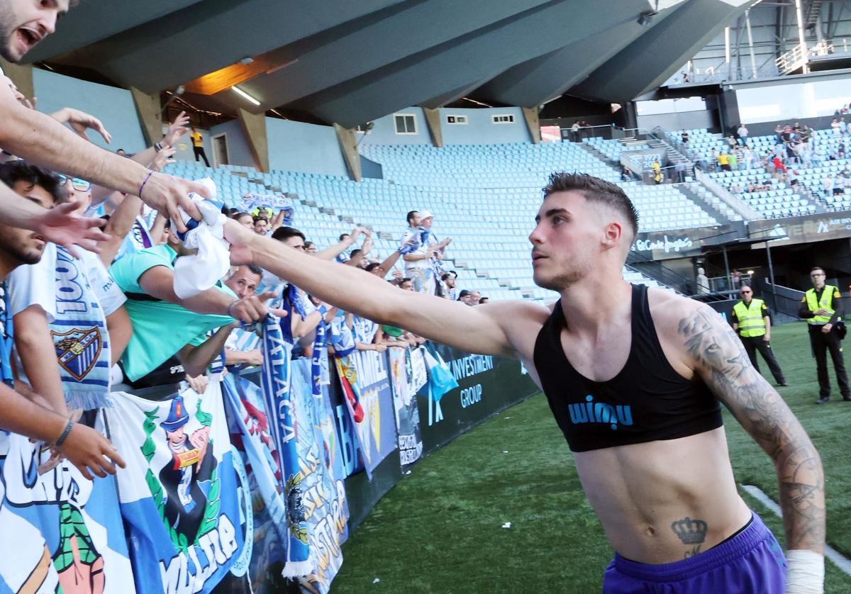 El jugador del Málaga Roberto Fernández regala su camiseta a un aficionado tras el partido contra el Celta B en Balaídos.