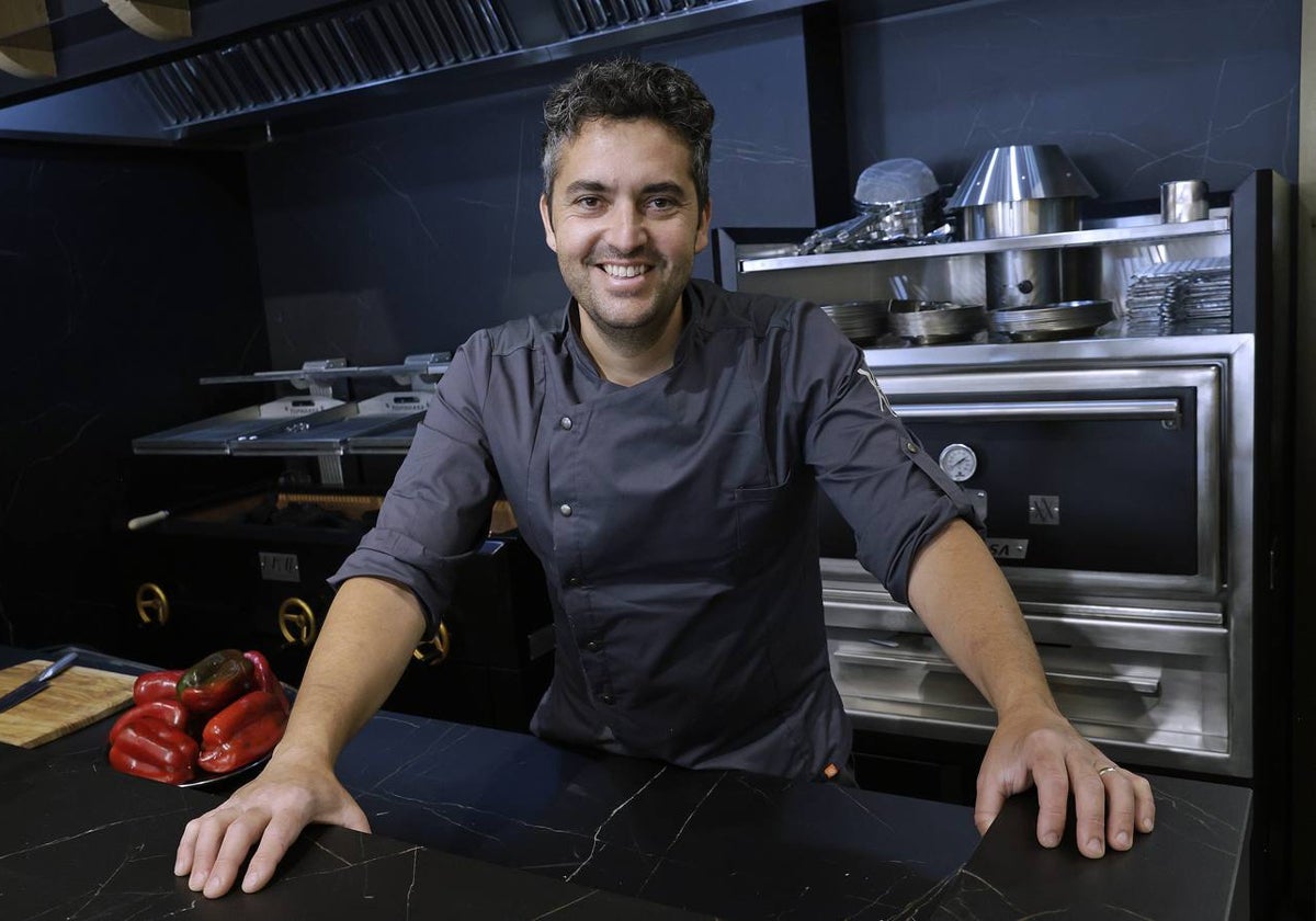 Juanjo Carmona, en la barra de Aviva, con la parrilla y el horno de brasa al fondo.