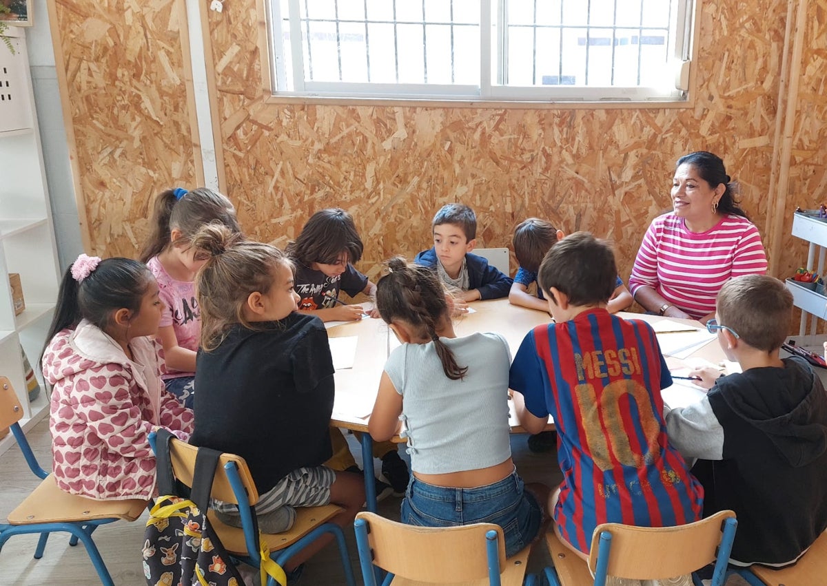 Imagen secundaria 1 - Taller de costura. Conchi dio a los alumnos lecciones de patronaje y una niña toma medidas a una alumna de San Telmo.