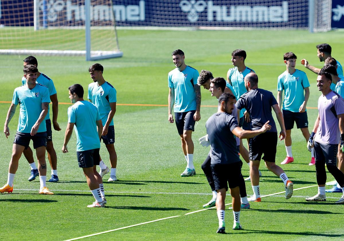 El delantero del Málaga, Roberto Fernández, en el centro, sonríe durante el entrenamiento de este miércoles en La Rosaleda.