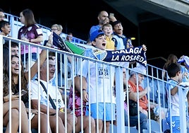 Un joven aficionado del Málaga anima en la grada de La Rosaleda.