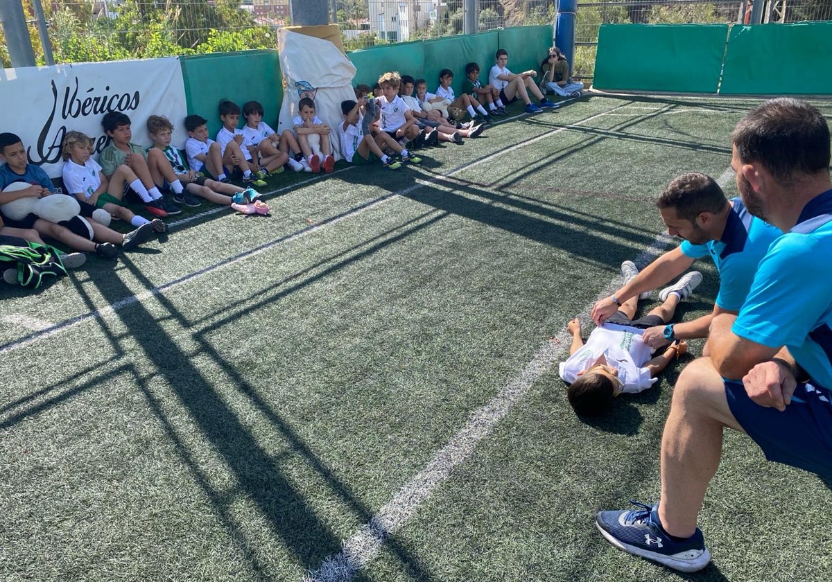 Los jugadores de La Mosca atienden las instrucciones de sus entrenadores sobre primeros auxilios y la técnica de RCP.