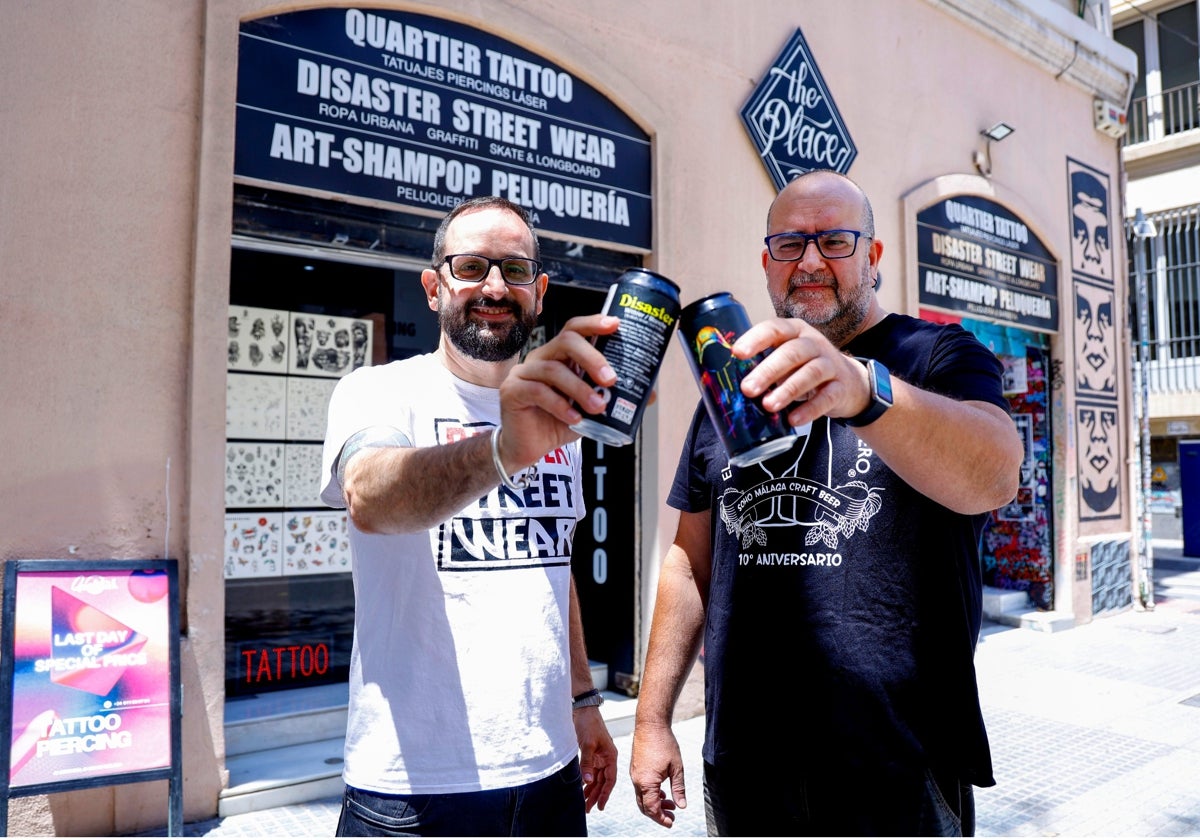 Manuel Criado y David Márquez brindan con la cerveza delante de una de la tiendas.