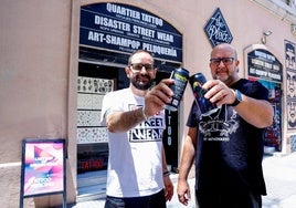 Manuel Criado y David Márquez brindan con la cerveza delante de una de la tiendas.