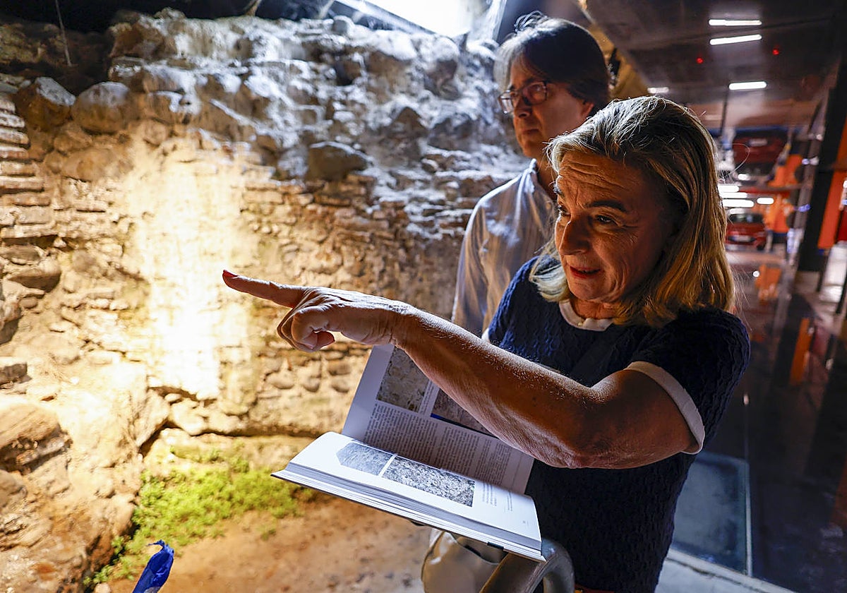 Carmen Peral señala la muralla del Castil de los Genoveses, que se conserva en el parking de la Marina.
