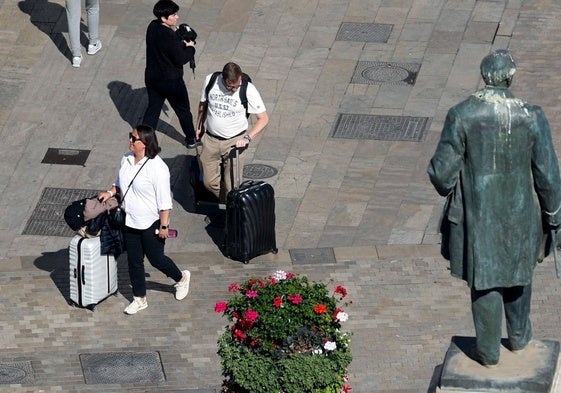 Turistas, con sus maletas, por el Centro de Málaga.