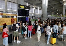 Viajeros pendientes de las pantallas, hoy en el aeropuerto de Málaga.