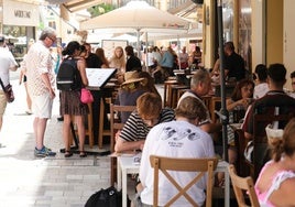 Turistas miran la lista de precios de la carta de un restaurante de Málaga.