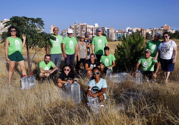 Foto de familia: hay voluntarios de todas las edades. Aquí posan con algunos de sus árboles más crecidos. Llevan sembrando desde hace siete años.