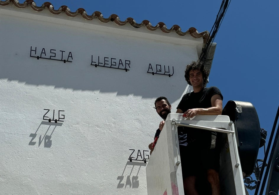 LUCE coloca palabras de hierro en una pared del pueblo.