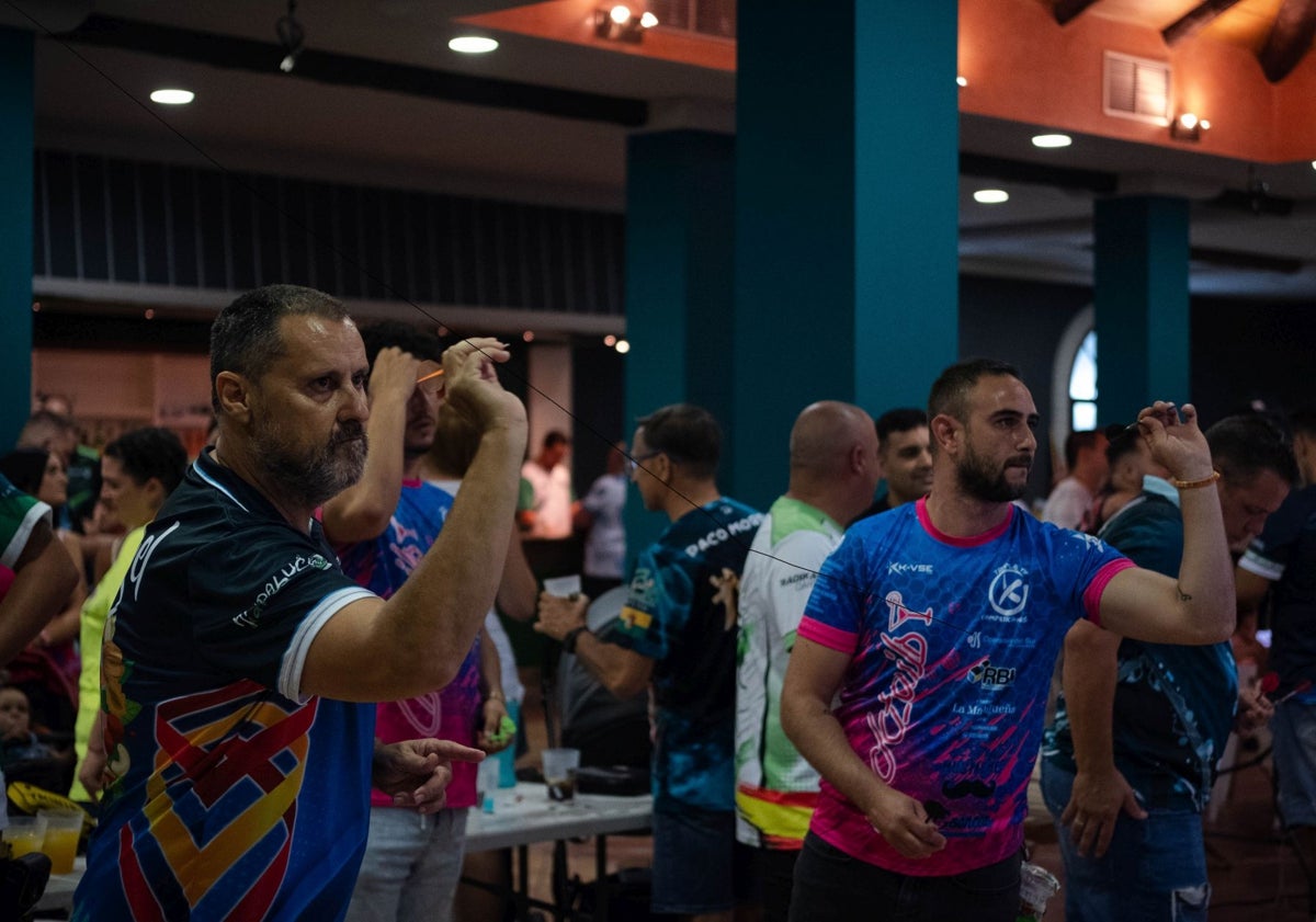 Imagen principal - Jugadores durante la celebración de la tercera edición del torneo del Club de Dardos de Pizarra en la primera imagen; Riky Pérez en la segunda, y una de las dianas del torneo en la tercera.