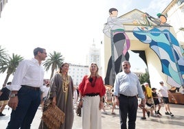 La consejera Carolina España, de rojo, ante la portada de la feria en la entrada de la calle Larios.