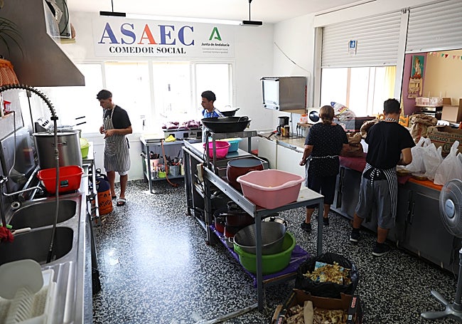 Voluntarios sin hogar trabajando en la cocina de Asaec.