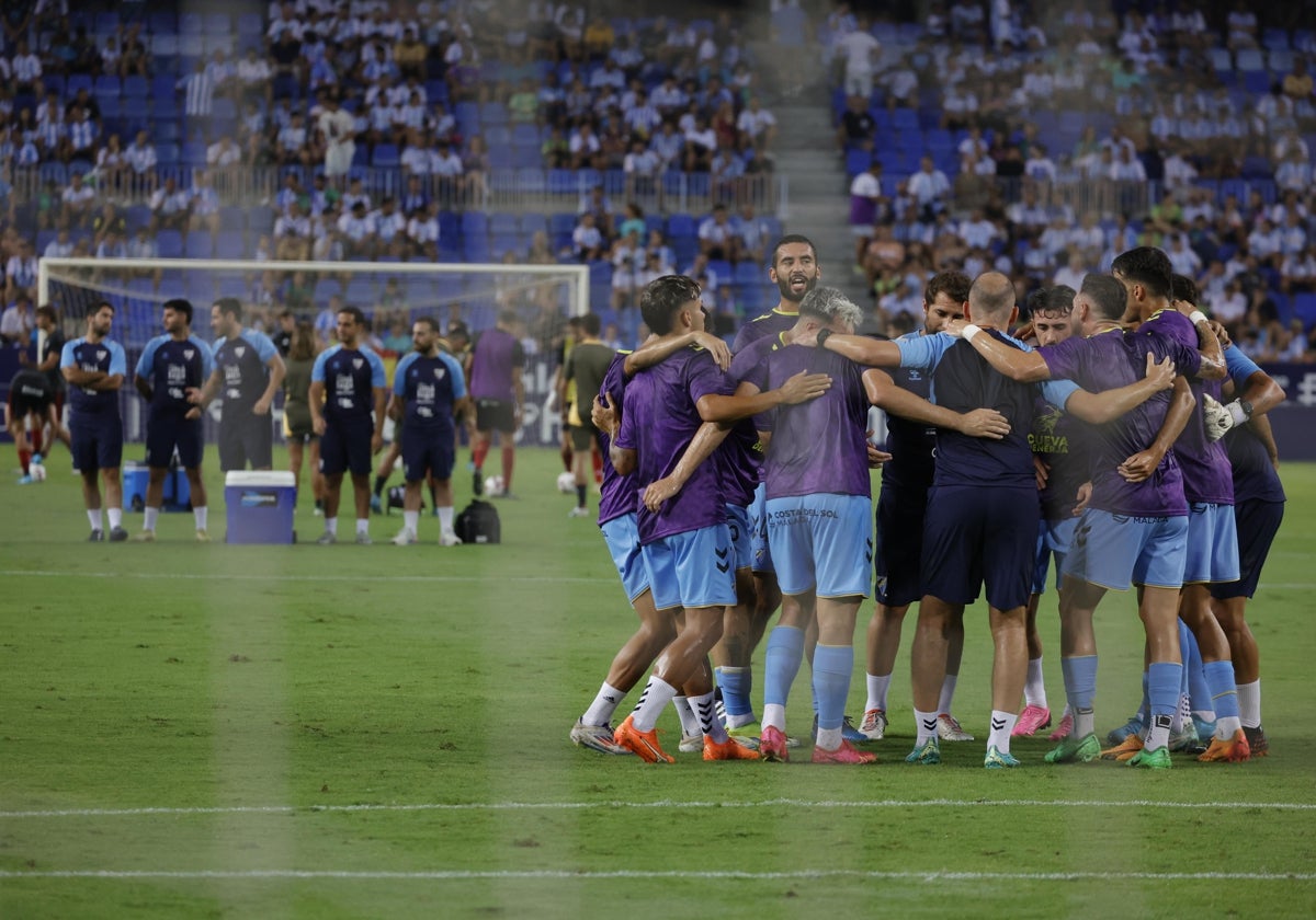 Los jugadores del Málaga CF calientan en La Rosaleda para enfrentarse al Mirandés.