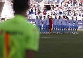 Los jugadores del Málaga, durante el minuto de silencio por la muerte de Fernando Puche.