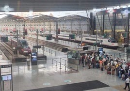 Viajeros esperan en cola a un tren en la estación María Zambrano de Málaga.