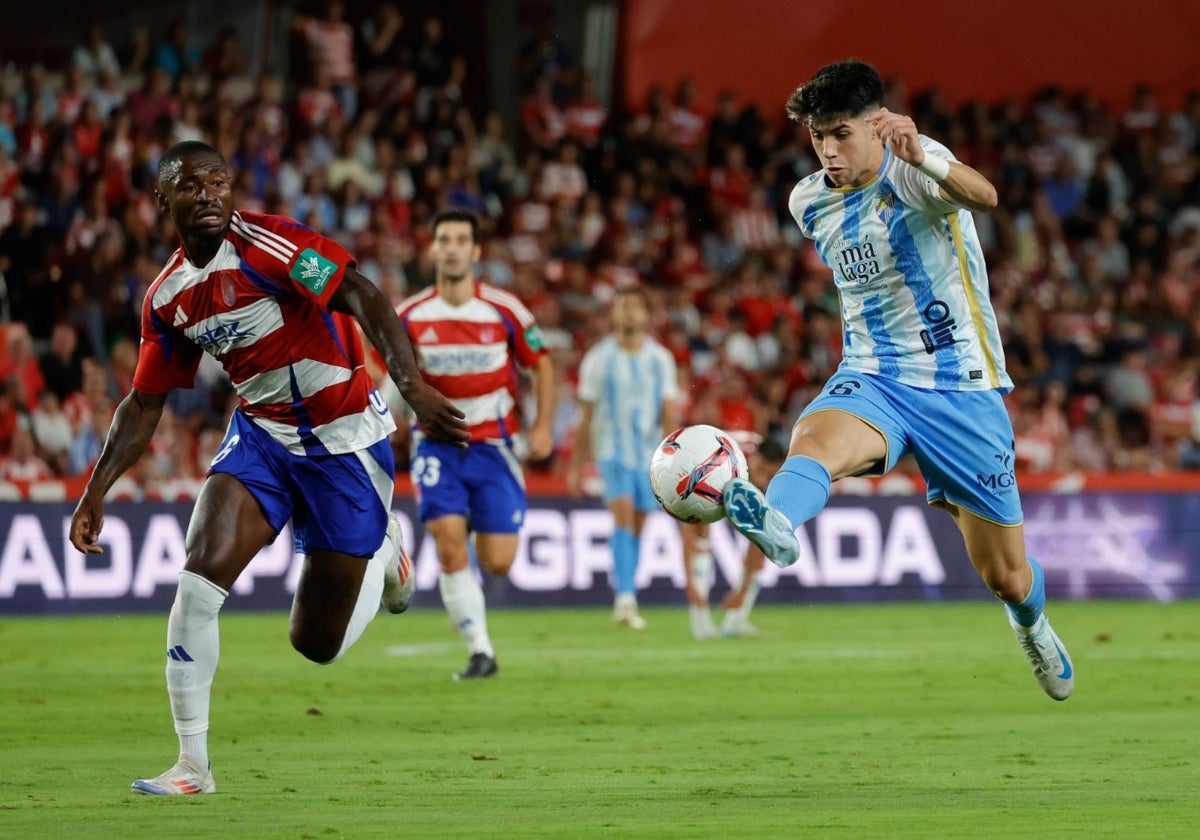 Antoñito conduce el balón perseguido por Hongla durante el partido del viernes en Los Cármenes.