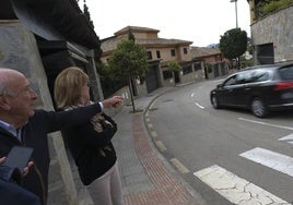 Emilio Mena señala a un coche que baja por la calle a gran velocidad.