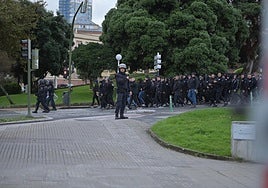 Ultras del Málaga rodeados por agentes de la Policía Nacional.