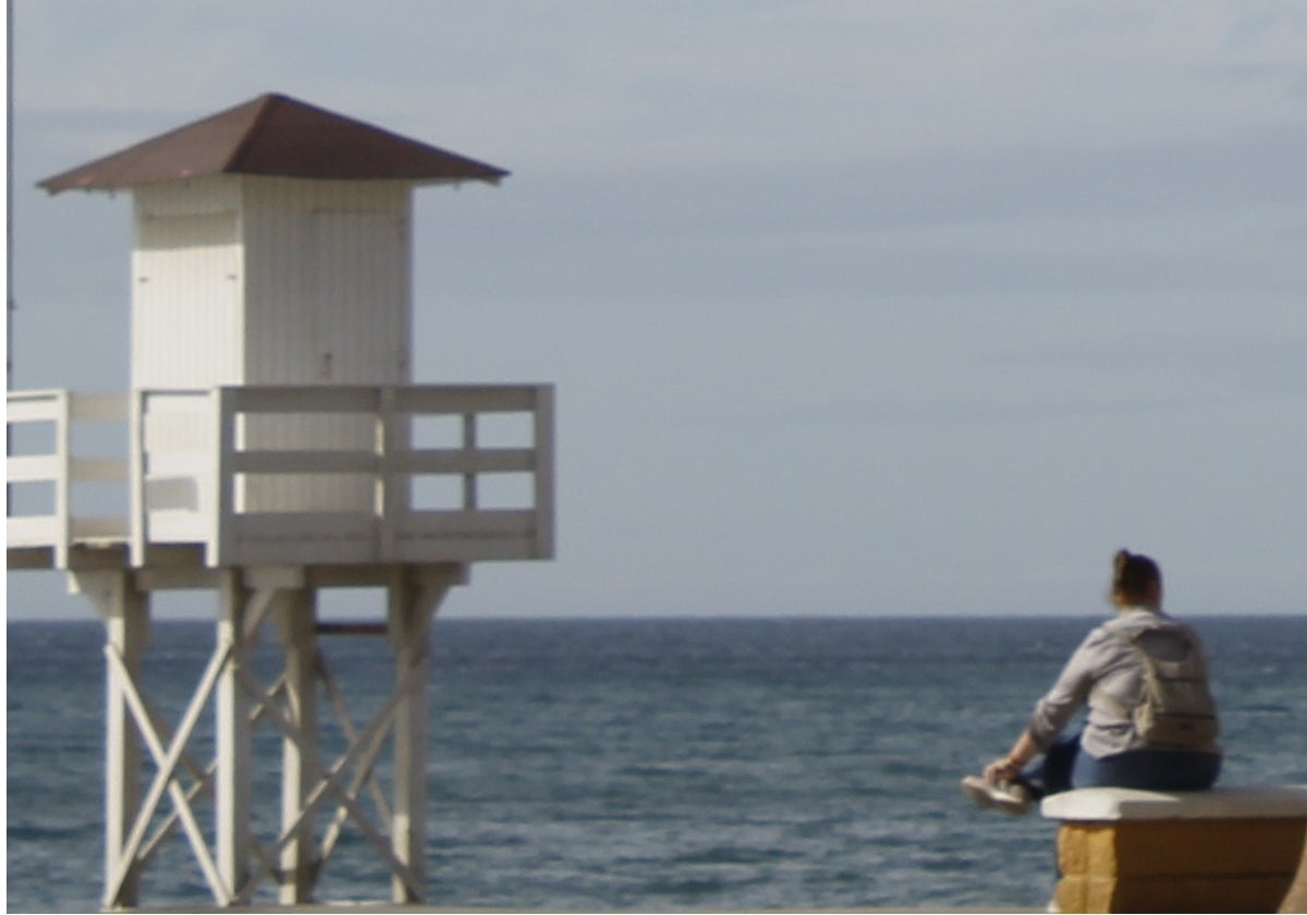 Una mujer, sentada frente al mar, en Rincón de la Victoria.