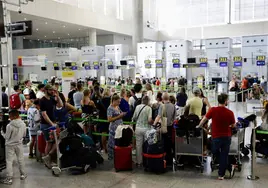 Turistas esperan en los mostradores de facturación del aeropuerto.