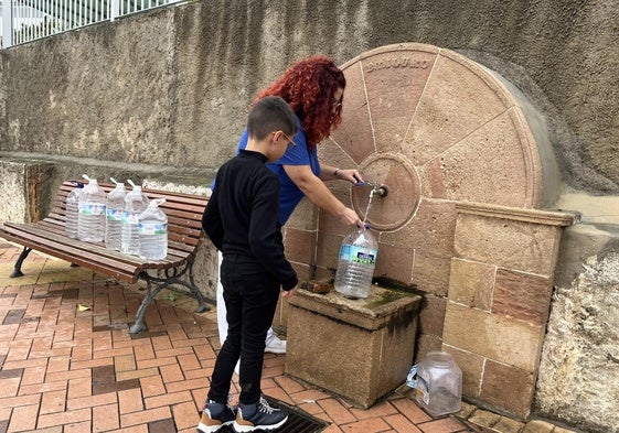 Paqui Abello, una de las vecinas de Álora, rellena sus garrafas en la única fuente con agua del municipio.