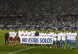 La pancarta de apoyo a los daminificados por la DANA con la que salió ayer el Málaga, además de con camisetas alusivas a la catástrofe.