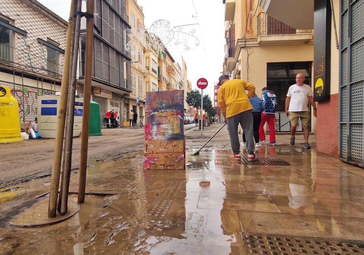 La calle y negocios de Carretería, afectados por el barrio que ha dejado la inundación de la vía.