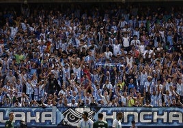 Aficionados del Málaga animan a su equipo en La Rosaleda.