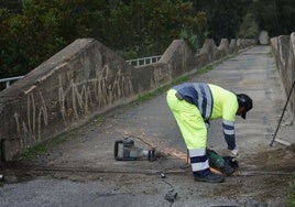 Un operario realiza las obras en el puente de río Pereilas.