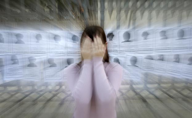 Casandra posa ocultando su rostro ante los carteles de las mujeres asesinadas en los últimos meses.