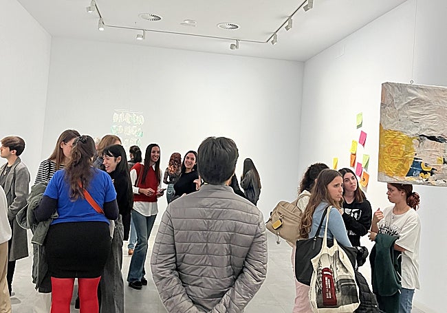 Visitantes en la inauguración de la exposición observan las diferentes obras.