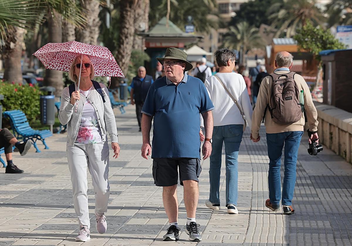 Dos personas pasean por el paseo marítimo en Málaga este martes.