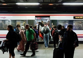 Viajeros entran y salen de un tren de Cercanías de la Costa.