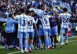 Los jugadores celebran con el banquillo el último gol del Málaga, el de Dioni.