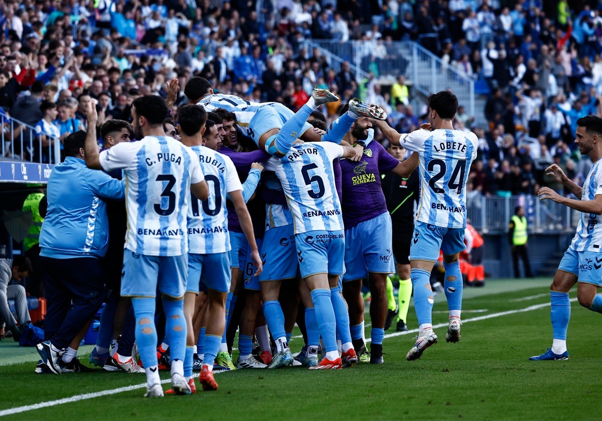 Los jugadores del Málaga celebran con su banquillo el gol de Dioni frente al Almería.