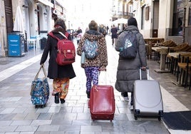 Turistas se dirigen por el Centro de Málaga a sus alojamientos.