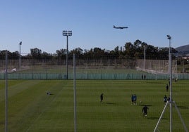 En esta imagen tomada desde las gradas del estadio principal de La Academia se observan en primer lugar los dos campos de hierba natural que se construyeron inicialmente y al fondo se encuentra ya listo el quinto terreno de juego, que es de césped artificial. Por encima, a la derecha, queda espacio suficiente para que quepan un nuevo campo y la residencia