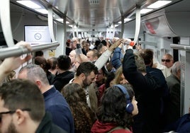 Vagón de un Cercanías de la Costa, lleno de pasajeros.