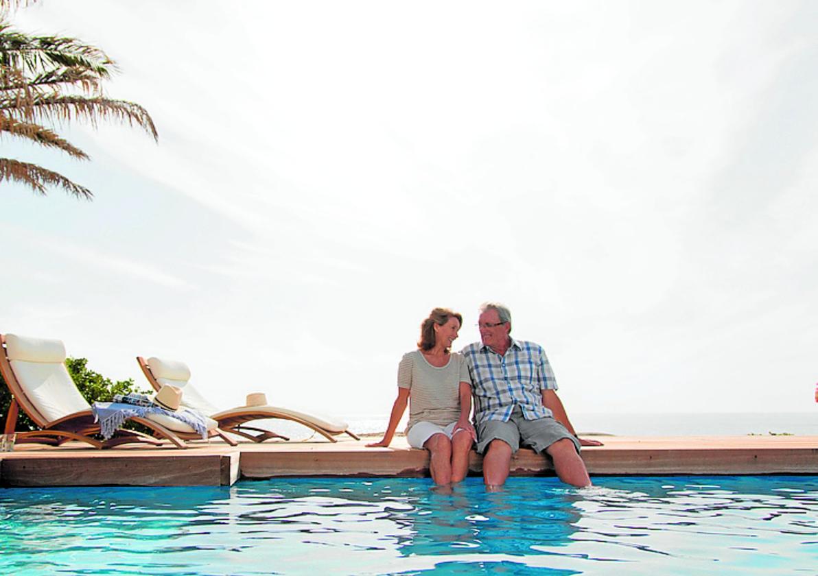 Una pareja disfruta de la piscina en un complejo hotelero.