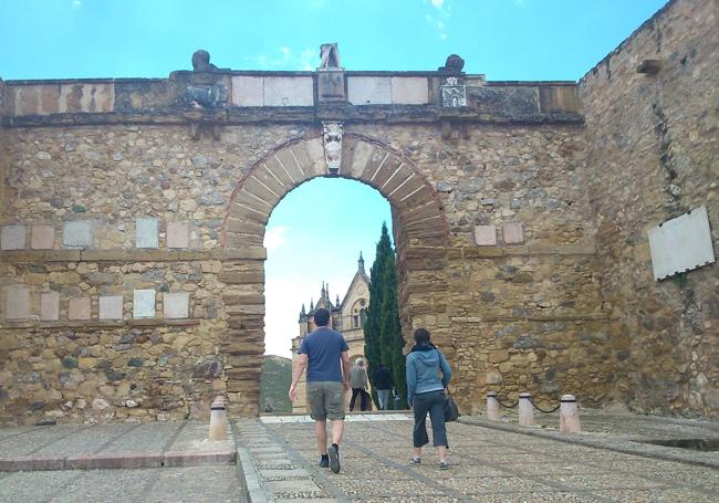 Una pareja se adentra en la Alcazaba de Antequera por el Arco de los Gigantes.