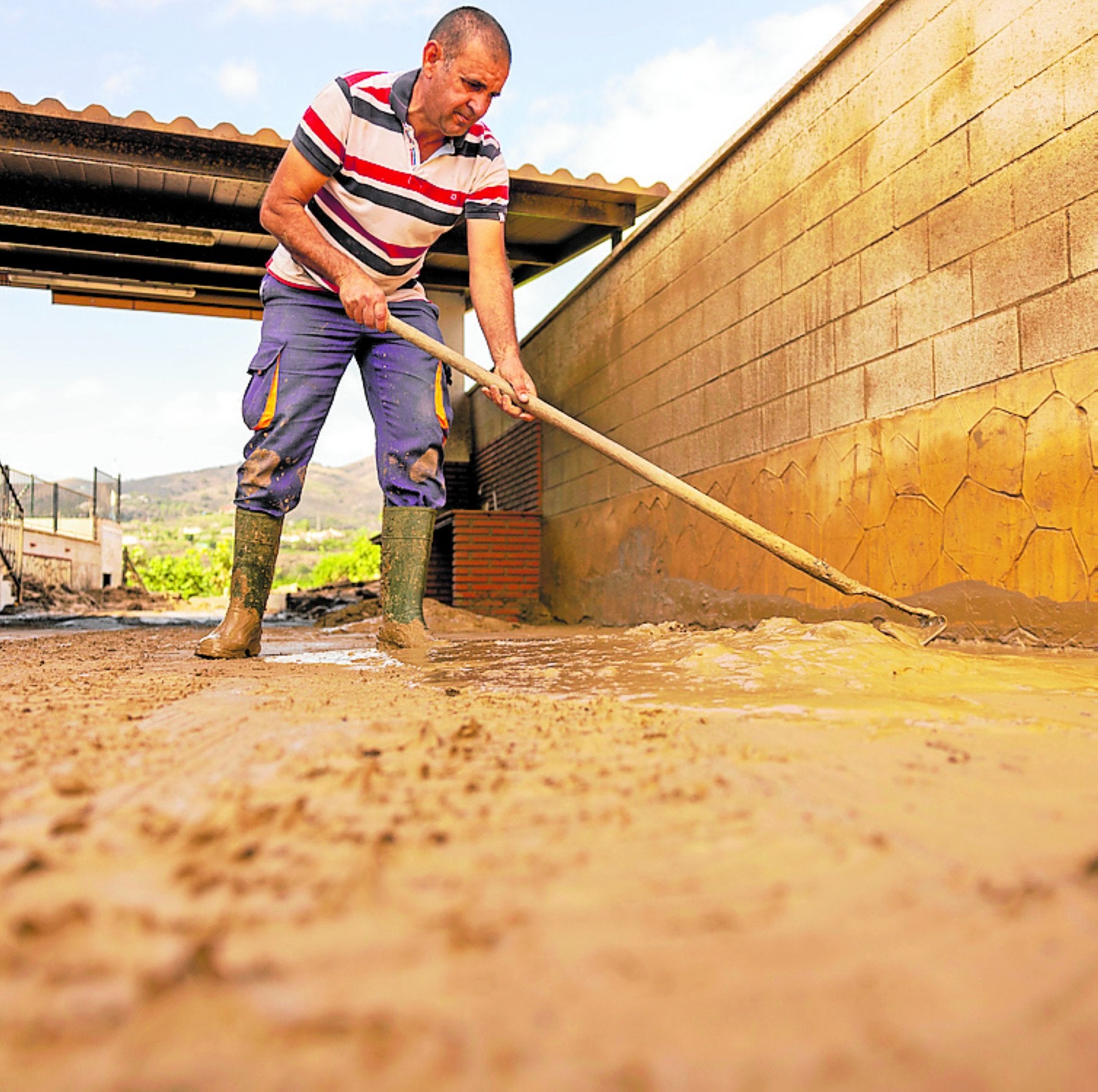 Un agricultor intenta paliar los efectos de las inundaciones en su finca.