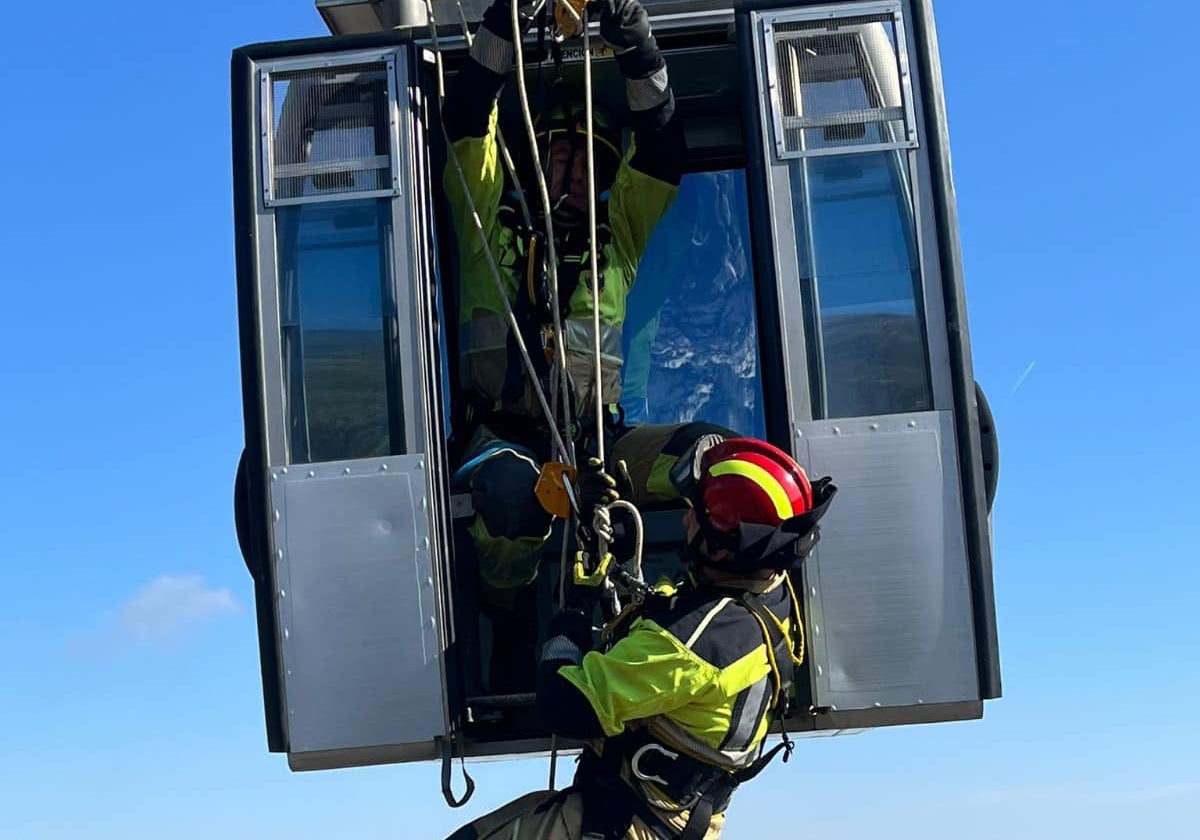 Bomberos en el interior de una de las cabinas del teleférico.